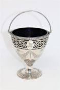 An ornate George III silver sugar basket, with family crest, blue glass liner, maker W P,