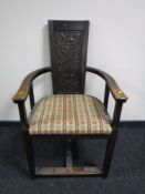An early 20th century Arts and Crafts style oak armchair with carved panel back, width 62cm.