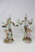 A pair of continental porcelain four-sconce candelabra decorated with cherubs, height 37cm.