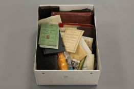 A box containing paper ephemera, leather wallets, instruction booklets etc.