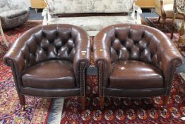 A pair of early 20th century brown Chesterfield style club armchairs,