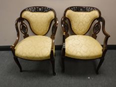 A pair of carved mahogany armchairs in gold upholstery, width 60cm.