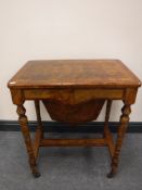 A 19th century burr walnut work table, on turned legs raised on castors, width 61cm.