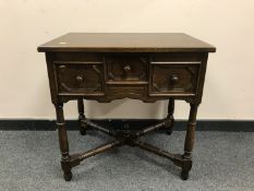 A period style oak side table fitted with three drawers, width 65 cm.