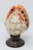 A Victorian carved cameo conch shell depicting The Three Graces, on turned wooden base, height 20.