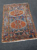 A Kazak rug, with two geometric medallions upon a blue field,