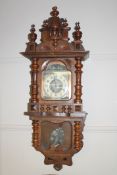 A 19th century carved oak 8 day wall clock with enamel dial, height 112cm.