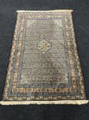 A fringed Persian rug on blue ground, 173cm by 114cm.