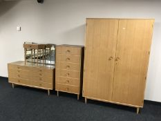 A mid 20th century light oak four piece bedroom suite, comprising of double door wardrobe,