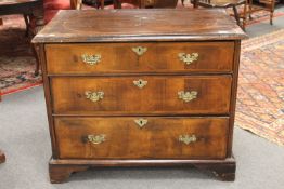 A George II walnut chest of three drawers, raised on bracket feet, width 95cm.