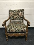 A carved oak armchair upholstered in floral fabric, width 62cm.