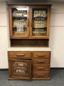 An early twentieth century kitchen cabinet with formica top and advertising decoration,