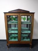 A 19th century Art Nouveau style mahogany display cabinet with leaded glazed doors, width 91cm.