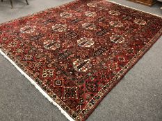 A Bakhtiari carpet, West Persia, of traditional design on red ground, 390 cm x 306 cm.