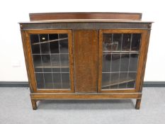 An early 20th century glazed oak cabinet, width 154cm.