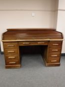 A 1930's oak roll top desk, fitted nine drawers, width 152cm.