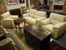 A cream leather three piece lounge suite comprising of two seater settee and pair of armchairs