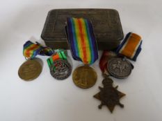 A Princess Mary tin containing five medals including the 1914-15 Star, two Victory Medals,