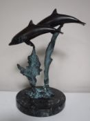 A bronze figure of two dolphins on marble base
