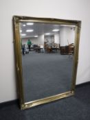 A large ornate gilt framed bevelled overmantel mirror