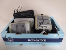 A box of three Super Nintendo entertainment systems with leads and controllers,