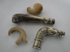 Four antique walking stick heads including a Victorian ivory example with silver inlay,