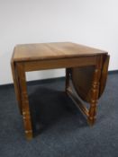 A blond oak drop leaf dining table