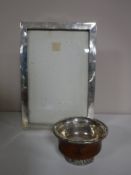 A sterling silver photo frame and a sterling silver and wood finger bowl.