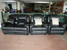 A black leather-look three piece lounge suite with scatter cushions