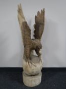 A carved wooden figure of a golden eagle