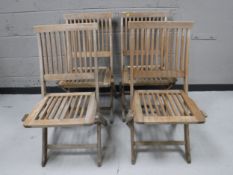 A set of four folding teak garden chairs