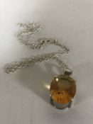 An 18ct white gold mounted citrine pendant suspended upon a silver chain