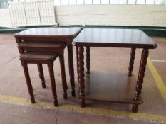 A two tier lamp table and nest of three tables in a mahogany finish