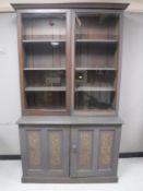 A painted Victorian glazed door bookcase fitted with cupboards beneath