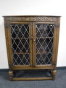 A carved oak leaded glass door bookcase