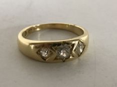 A yellow gold three stone gypsy style diamond ring, size M/N.