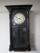An early twentieth century oak cased wall clock with silvered dial