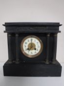 A Victorian slate mantel clock with enamel dial