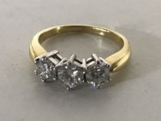 An 18ct gold three stone diamond ring, size K/L,