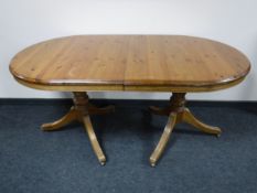 An oval Ducal pine twin pedestal extending table