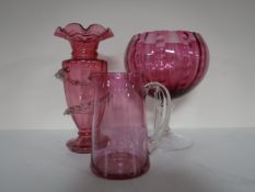 An antique cranberry glass jug and vase with later cranberry glass bowl