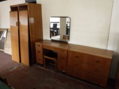 A mid twentieth century oak double door wardrobe together with dressing table and three drawer