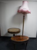 An oak standard lamp with shape together with an oval mahogany coffee table on claw and ball feet