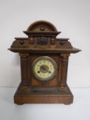 An Edwardian pine mantel clock with enamel dial