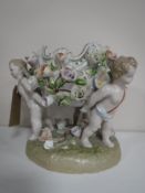 A continental bowl with flower decoration surmounted on three cherubs,