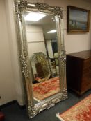 A tall silvered ornate mirror, 103cm by 203cm.