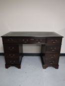 A mahogany twin pedestal writing desk with inset green leather panel
