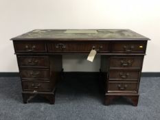 A mahogany twin pedestal writing desk with inset green leather panel