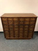 A Victorian and later post office cabinet fitted with forty-two fall front doors,