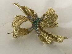 An 18ct gold diamond and emerald bow brooch, 20g,